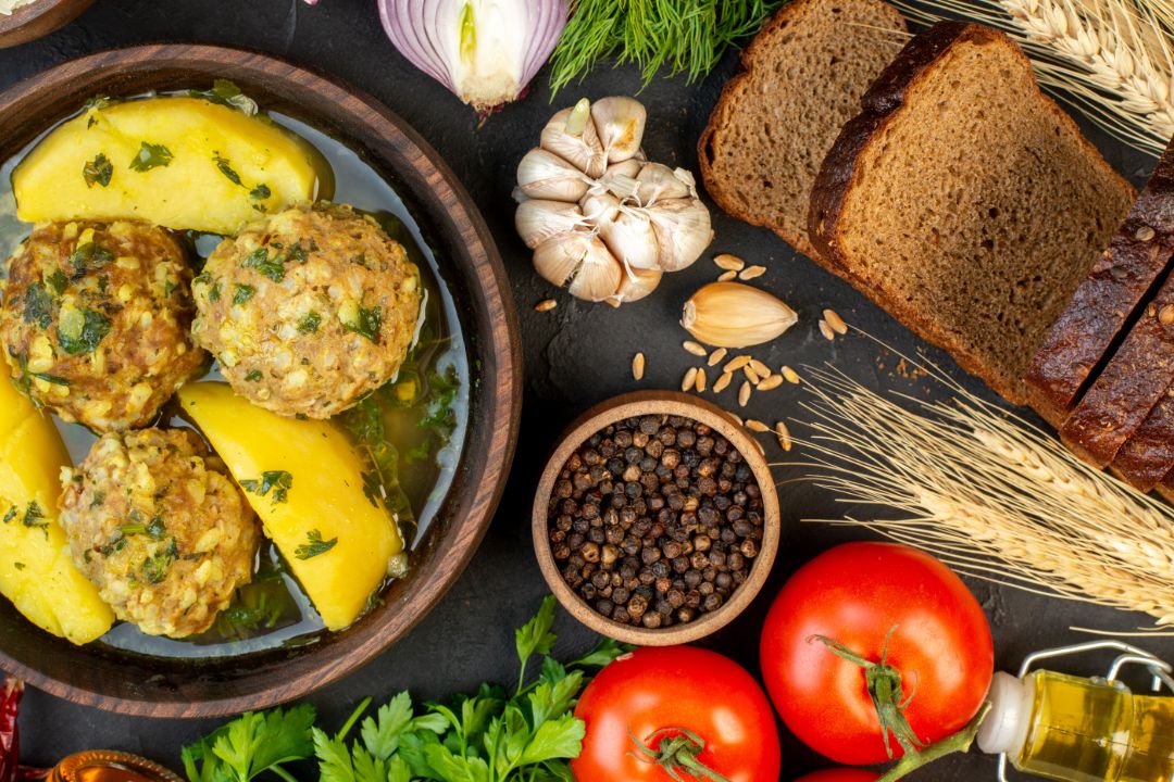 Foto Freepik view-tasty-meatball-meal-fresh-vegetables-spikes-bread-slices-green-fallen-oil-bottle-black-background